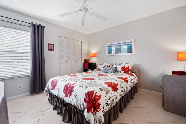 bedroom with a closet, baseboards, and light tile patterned floors