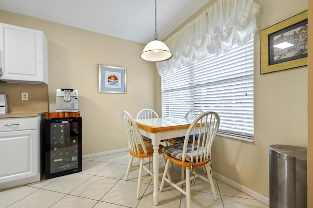 dining space featuring wine cooler, baseboards, and light tile patterned floors