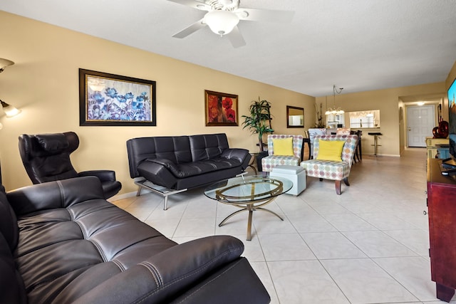 living area featuring ceiling fan with notable chandelier, baseboards, and tile patterned floors