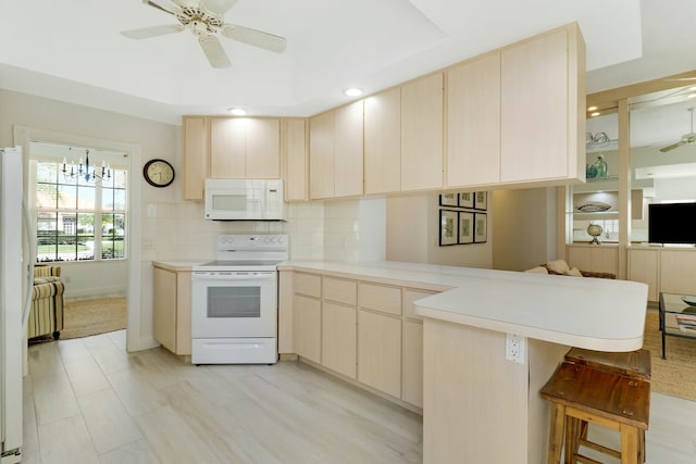 kitchen with tasteful backsplash, white appliances, a kitchen breakfast bar, kitchen peninsula, and ceiling fan