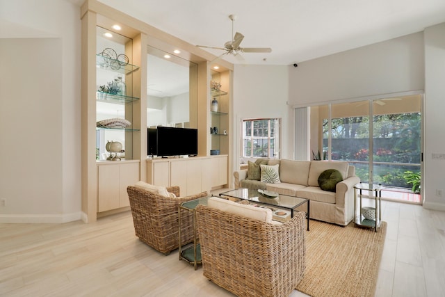 living room with ceiling fan, plenty of natural light, and light hardwood / wood-style floors