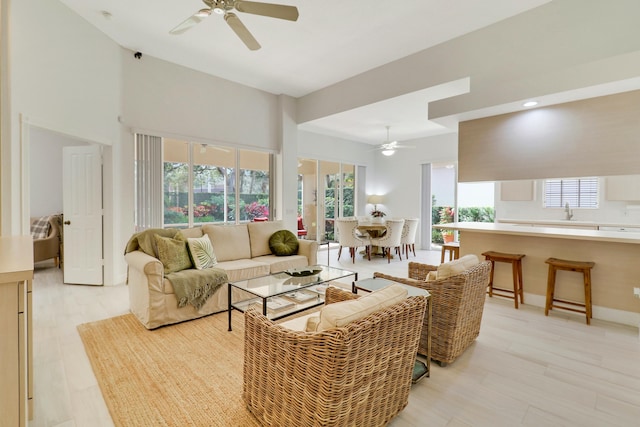 living room with sink, ceiling fan, and light hardwood / wood-style floors