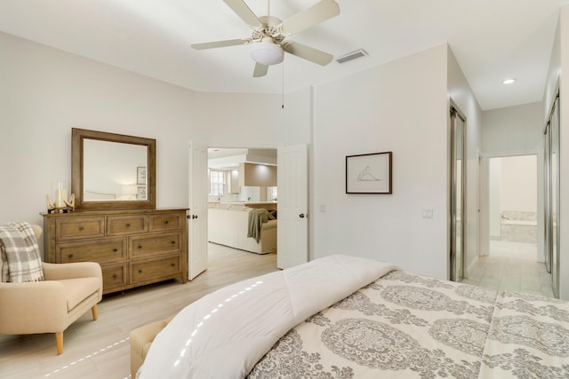 bedroom with connected bathroom and light wood-type flooring