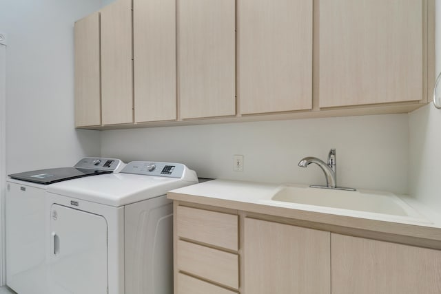 washroom with sink, washer and clothes dryer, and cabinets