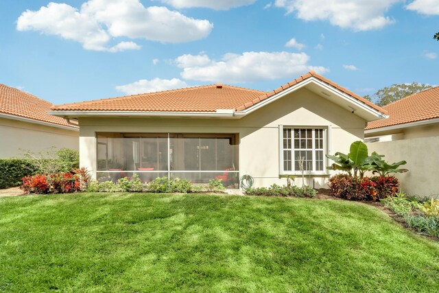 back of house with a yard and a sunroom