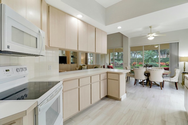 kitchen with light brown cabinetry, white appliances, kitchen peninsula, ceiling fan, and decorative backsplash