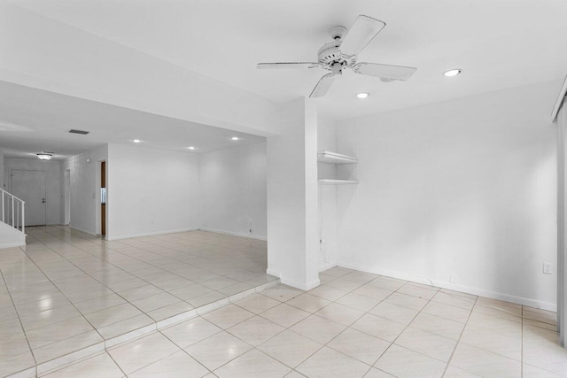 spare room with ceiling fan and light tile patterned floors