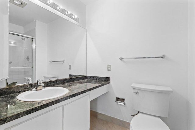 bathroom with tile patterned floors, vanity, toilet, and an enclosed shower