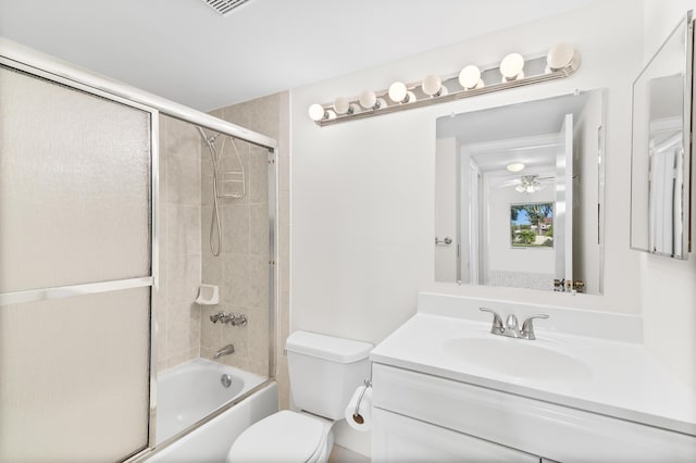 full bathroom featuring enclosed tub / shower combo, vanity, and toilet