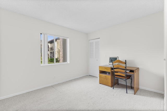 carpeted office space with a textured ceiling