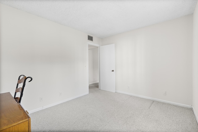 unfurnished office with carpet floors and a textured ceiling