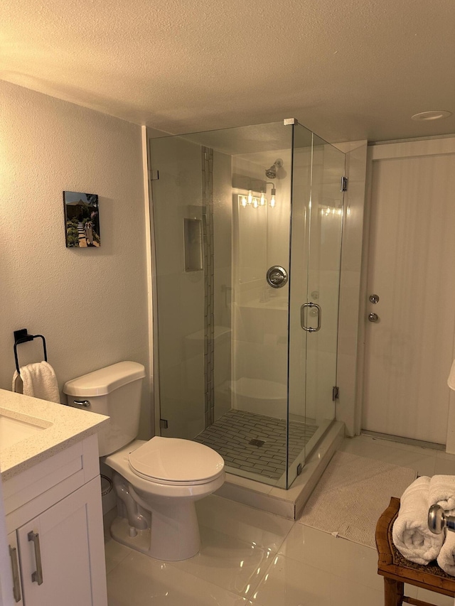 bathroom with toilet, a shower with shower door, a textured ceiling, vanity, and tile patterned flooring