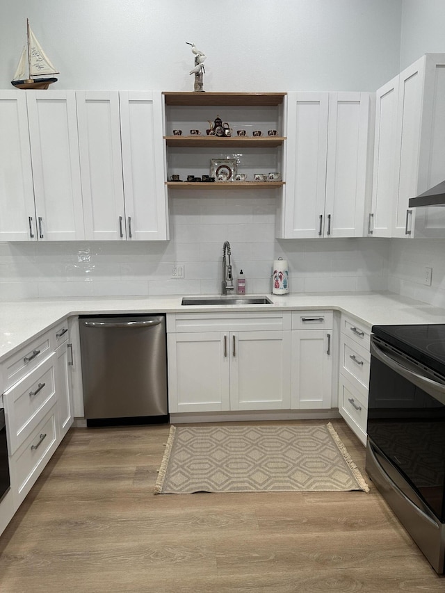 kitchen featuring stainless steel appliances, light hardwood / wood-style floors, sink, and white cabinets