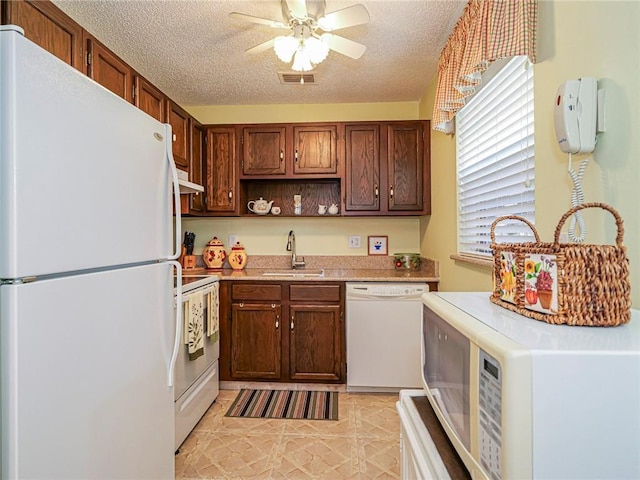 kitchen with sink, light tile patterned floors, white appliances, ceiling fan, and a textured ceiling