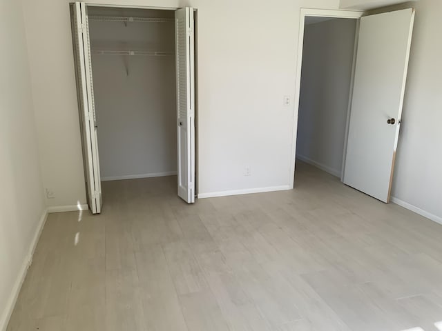 unfurnished bedroom featuring light hardwood / wood-style floors and a closet