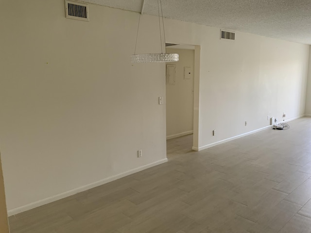 empty room featuring light hardwood / wood-style floors and a textured ceiling