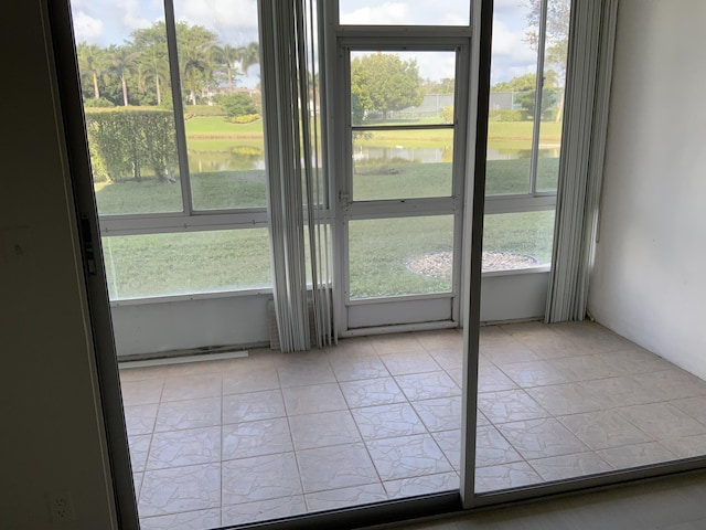 entryway featuring a water view and light tile patterned floors