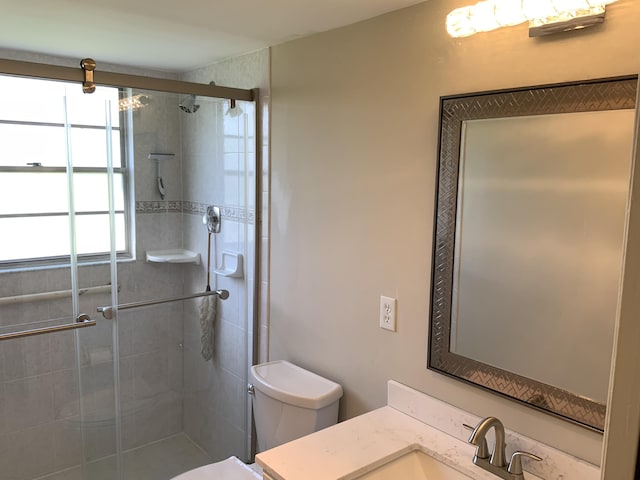 bathroom with an enclosed shower, vanity, and toilet