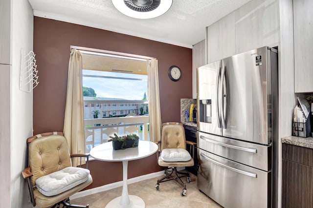 kitchen featuring stainless steel fridge with ice dispenser, light tile patterned floors, and a textured ceiling