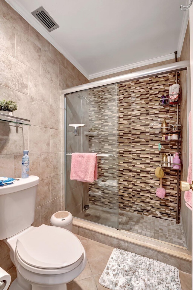 bathroom with tile walls, a shower with shower door, ornamental molding, and toilet