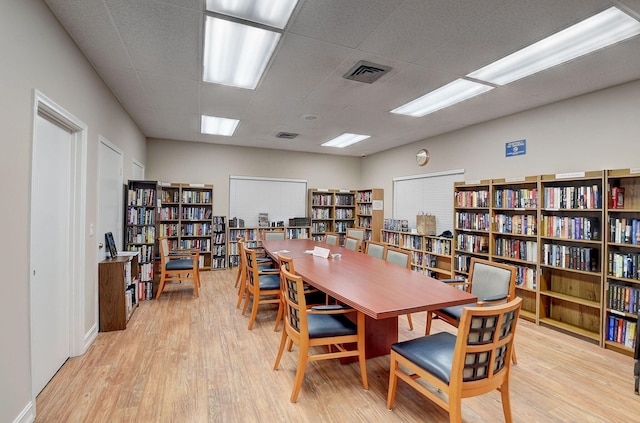 office space featuring a drop ceiling and light hardwood / wood-style flooring