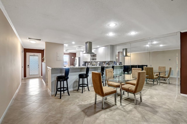 dining area featuring crown molding, a textured ceiling, and light tile patterned flooring