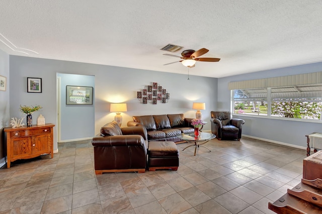 tiled living room with ceiling fan and a textured ceiling