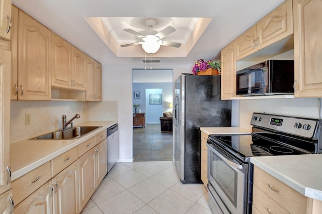 kitchen with stainless steel appliances, sink, light brown cabinets, and a tray ceiling