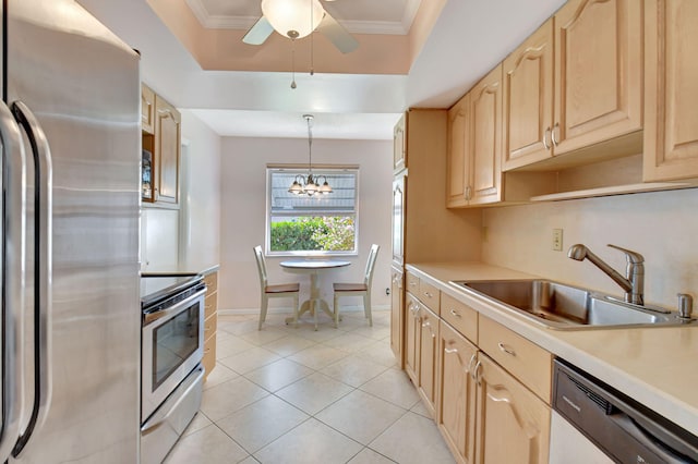 kitchen featuring sink, decorative light fixtures, light brown cabinets, a tray ceiling, and stainless steel appliances