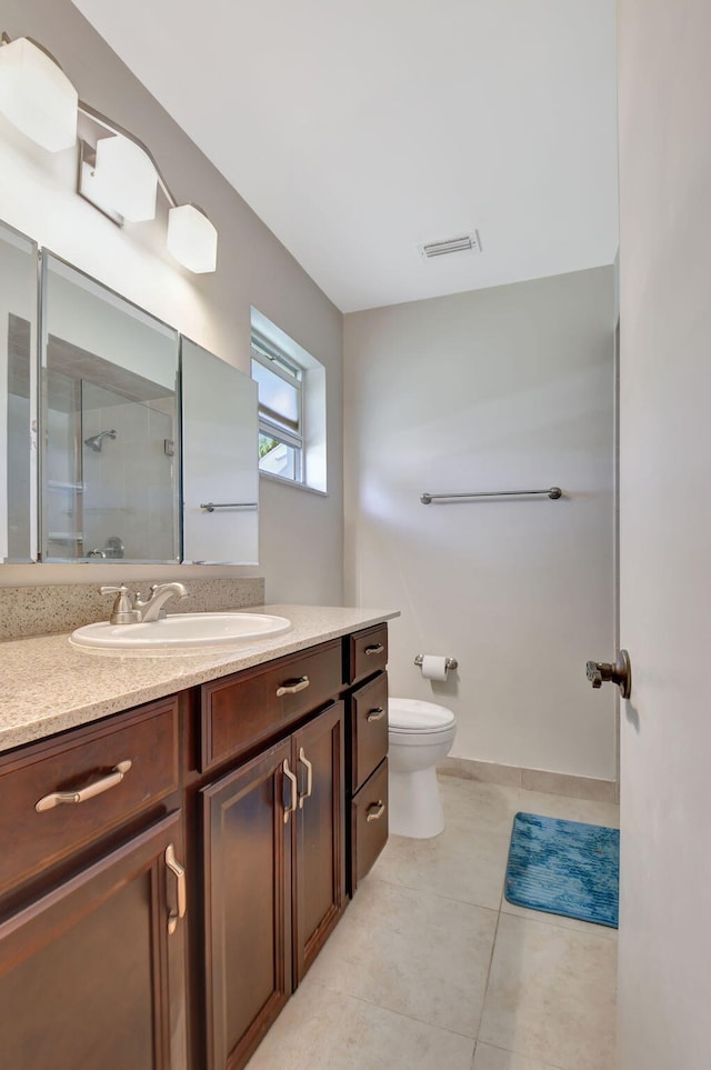 bathroom featuring vanity, toilet, a shower with door, and tile patterned flooring