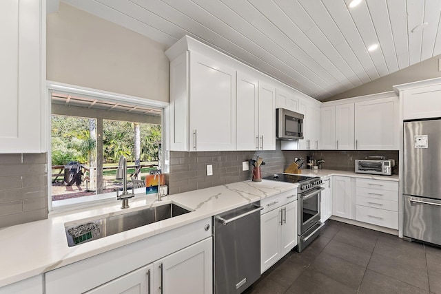 kitchen featuring light stone counters, sink, stainless steel appliances, and white cabinets