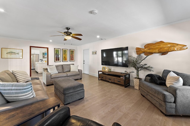 living room with crown molding, ceiling fan, and light hardwood / wood-style floors