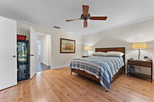 bedroom with ceiling fan, ornamental molding, and light hardwood / wood-style floors