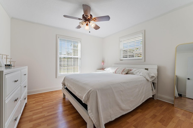 bedroom with crown molding, ceiling fan, and light hardwood / wood-style flooring