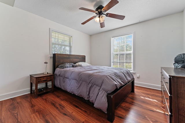 bedroom with dark wood-type flooring, multiple windows, and a textured ceiling