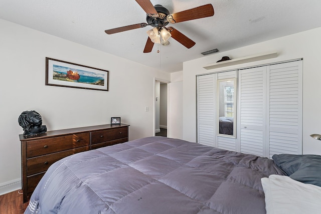 bedroom featuring ceiling fan, dark hardwood / wood-style floors, and a closet