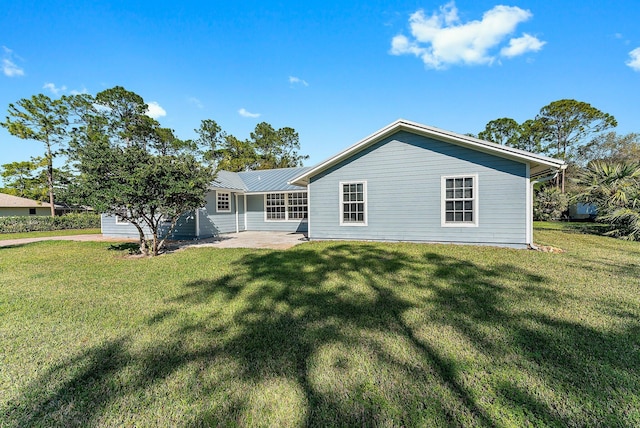 rear view of property with a patio and a lawn