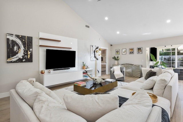 living room featuring light hardwood / wood-style flooring and high vaulted ceiling