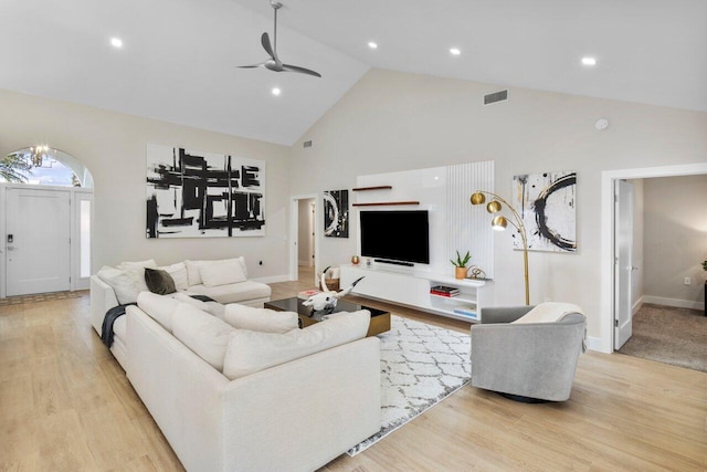 living room with ceiling fan, high vaulted ceiling, and light wood-type flooring