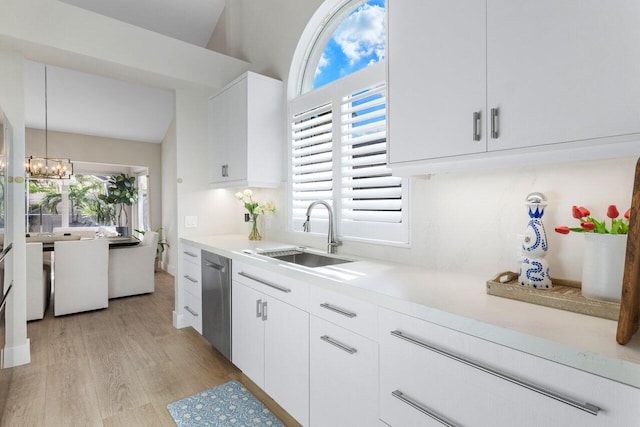 kitchen featuring sink, white cabinetry, decorative light fixtures, stainless steel dishwasher, and a healthy amount of sunlight