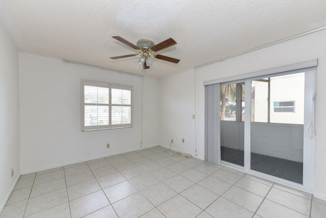 spare room featuring ceiling fan, a textured ceiling, and a wealth of natural light