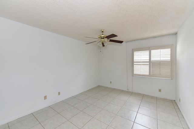 spare room with light tile patterned floors, a textured ceiling, and ceiling fan