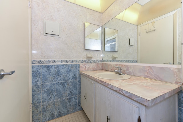 bathroom with vanity, tile patterned flooring, and tile walls