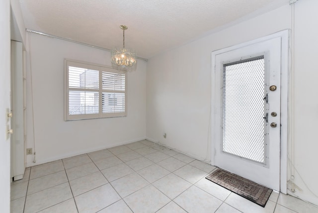 tiled entryway featuring an inviting chandelier and a textured ceiling