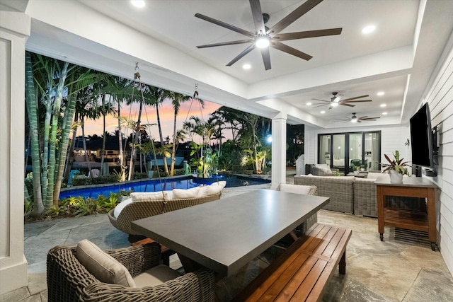 patio terrace at dusk with an outdoor living space and ceiling fan