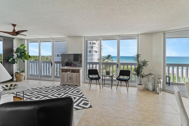 living room featuring expansive windows, a textured ceiling, and light tile patterned flooring