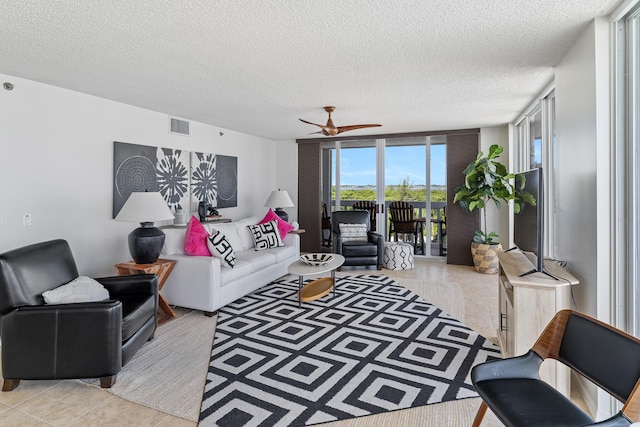 tiled living room featuring floor to ceiling windows and a textured ceiling