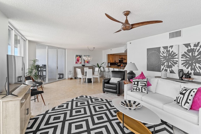 tiled living room with ceiling fan and a textured ceiling