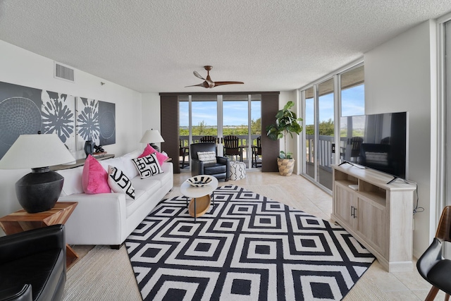 tiled living room featuring floor to ceiling windows and a textured ceiling