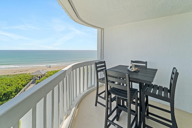 balcony featuring a water view and a view of the beach